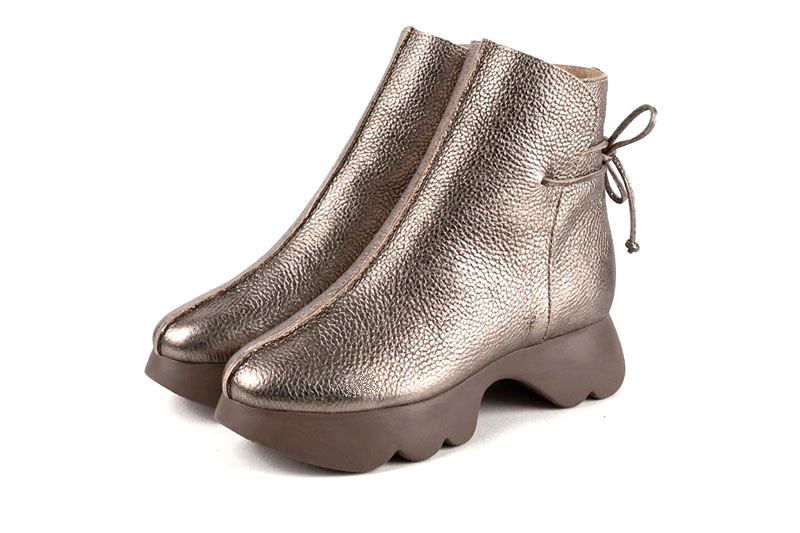 Feminine back lace-up ankle boots featuring romantic corset-style ties, designed for a striking silhouette from day to evening, in bronze leather with round toe and chunky rubber sculpted sole